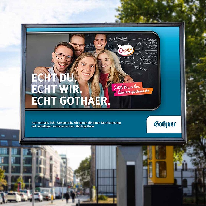 Das Bild zeigt drei junge Personen, die ein Selfie vor einem Neonsign machen.